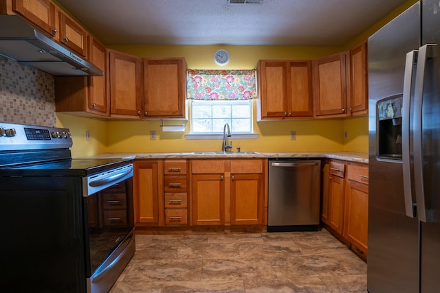 kitchen featuring stainless steel appliances, sink, and a textured ceiling