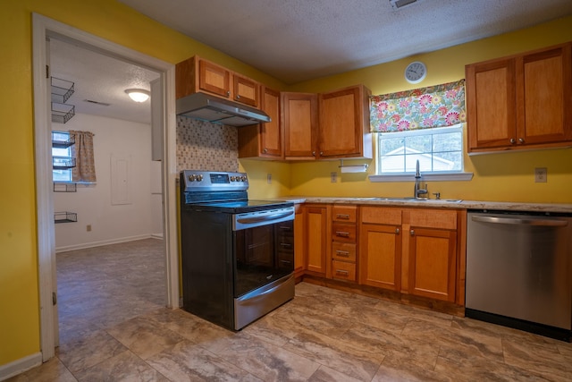 kitchen featuring stainless steel appliances, sink, and a textured ceiling