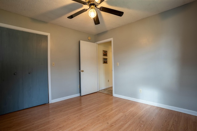 unfurnished bedroom featuring ceiling fan, light hardwood / wood-style flooring, and a textured ceiling