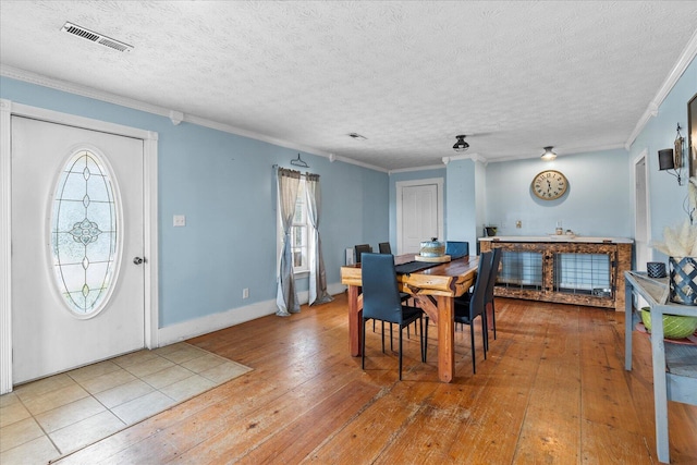 dining space with crown molding, a wealth of natural light, and light hardwood / wood-style floors