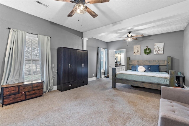 carpeted bedroom featuring ceiling fan, a textured ceiling, and ornate columns