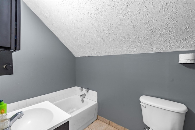 bathroom featuring vaulted ceiling, a bathtub, tile patterned flooring, toilet, and a textured ceiling