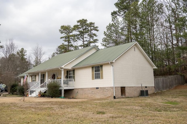 exterior space with cooling unit, covered porch, and a lawn