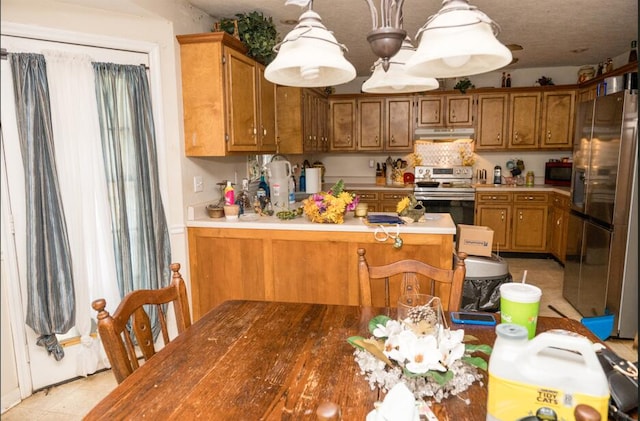 kitchen with pendant lighting, appliances with stainless steel finishes, and kitchen peninsula