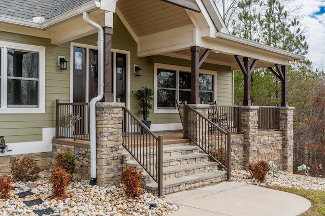 doorway to property with a shingled roof and covered porch