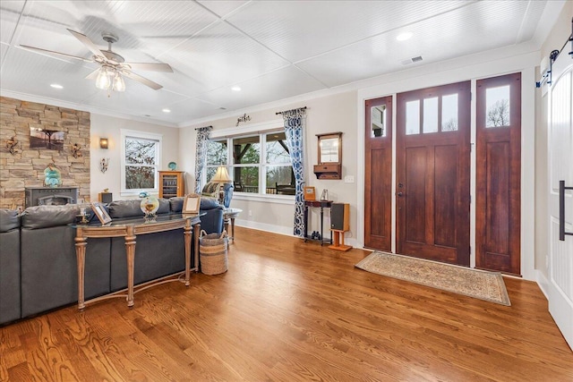 entrance foyer featuring wood finished floors, a ceiling fan, and crown molding