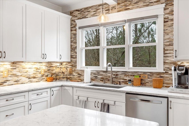 kitchen with decorative light fixtures, backsplash, stainless steel dishwasher, white cabinets, and a sink