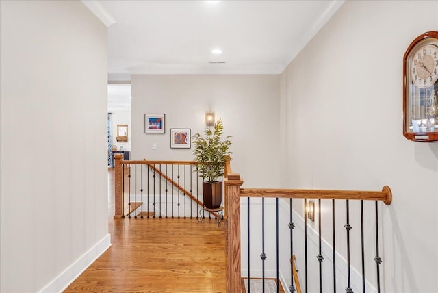 hall with baseboards, light wood-style flooring, and an upstairs landing