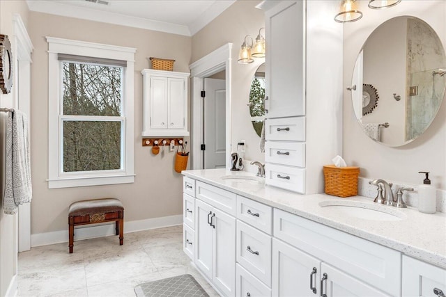 full bath with double vanity, ornamental molding, a sink, and baseboards