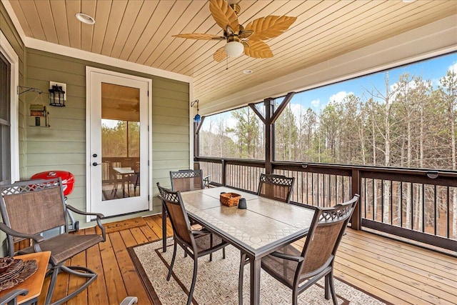 wooden deck featuring outdoor dining area and a ceiling fan