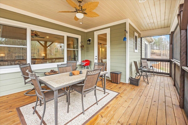 sunroom featuring wood ceiling and a ceiling fan