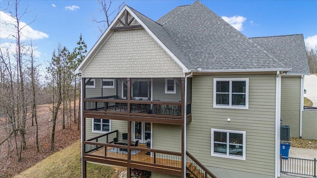 rear view of property with roof with shingles and a wooden deck