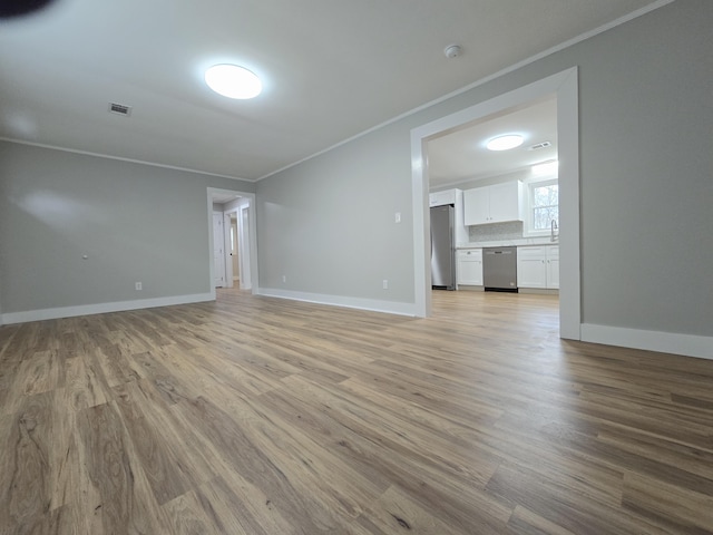 unfurnished living room featuring light hardwood / wood-style flooring and ornamental molding