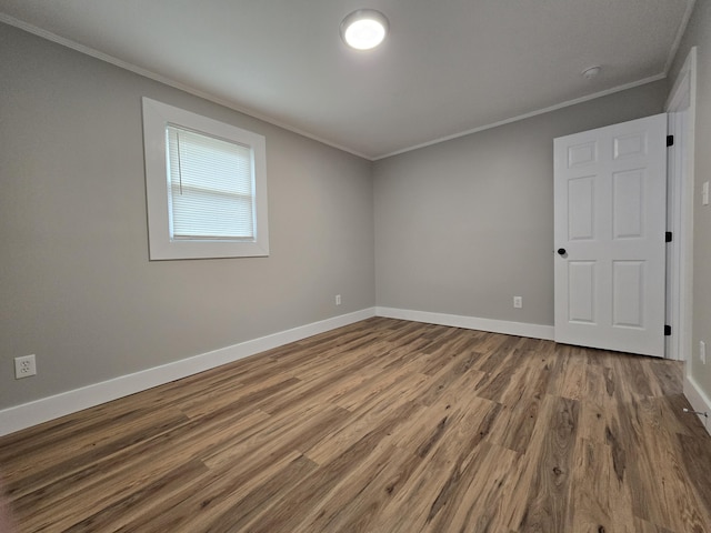 spare room with hardwood / wood-style flooring and crown molding