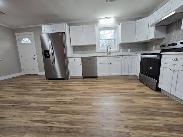 kitchen featuring sink, crown molding, white cabinetry, stainless steel appliances, and light wood-type flooring