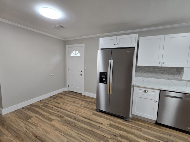 kitchen with light stone counters, crown molding, white cabinets, and appliances with stainless steel finishes