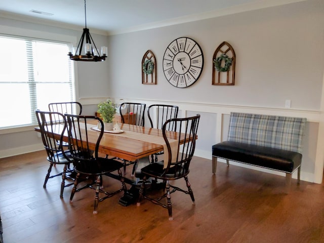 dining area featuring ornamental molding, a chandelier, and hardwood / wood-style floors