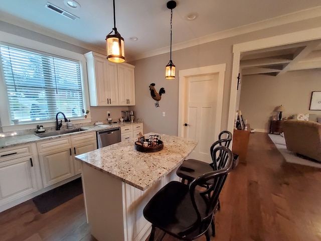 kitchen featuring light stone counters, dishwasher, sink, and a kitchen island