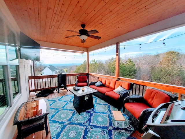 wooden terrace with ceiling fan and an outdoor living space