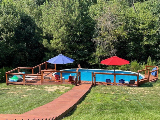 view of swimming pool with a wooden deck and a yard