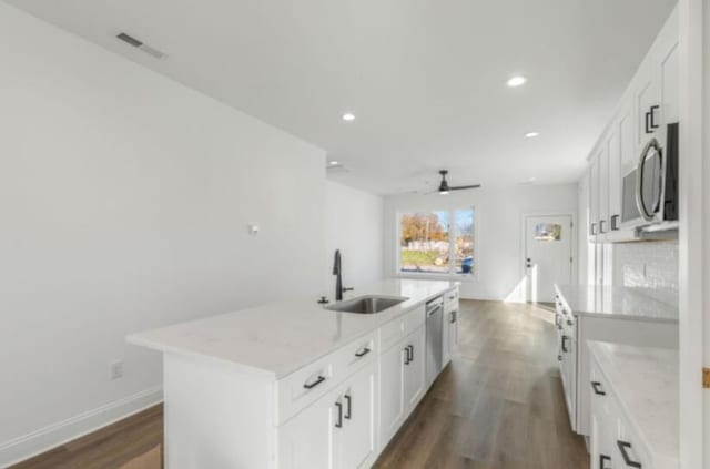 kitchen with a kitchen island with sink, sink, white cabinetry, and stainless steel appliances