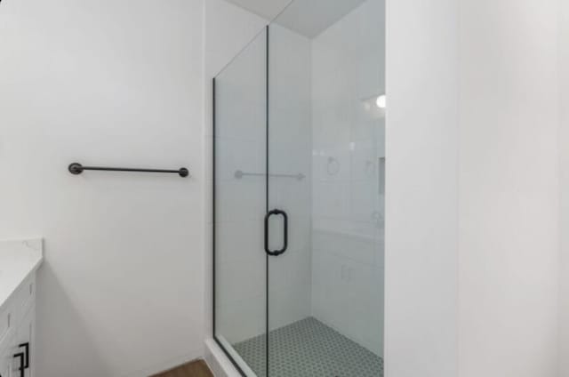 bathroom featuring walk in shower and vanity