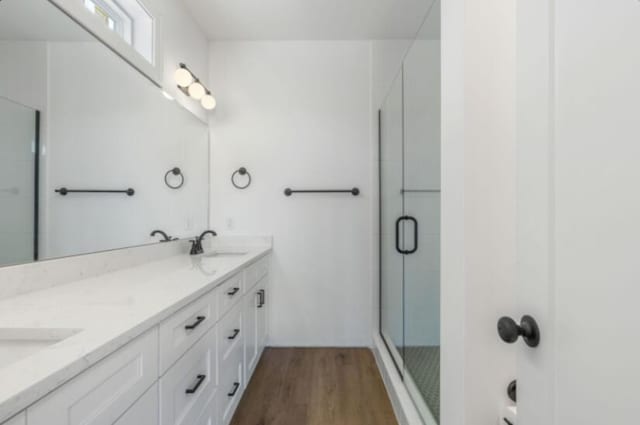 bathroom with an enclosed shower, vanity, and hardwood / wood-style flooring