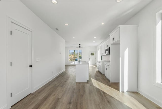 kitchen featuring white cabinetry, sink, a center island, and hardwood / wood-style floors