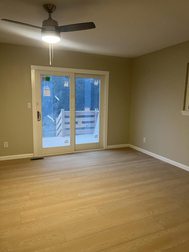 spare room with ceiling fan and light wood-type flooring