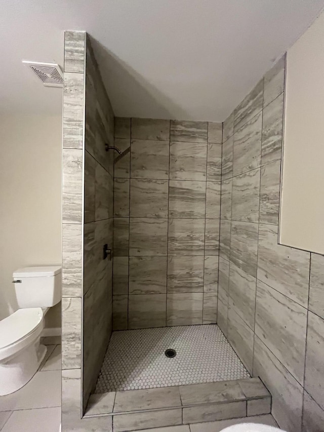 bathroom featuring toilet and tiled shower