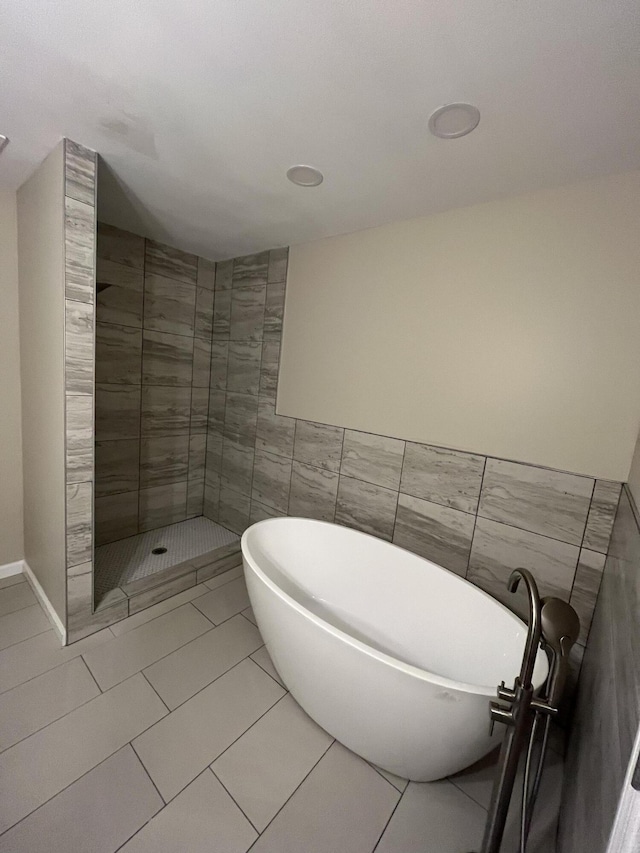 bathroom with tile patterned flooring, tiled shower, and tile walls