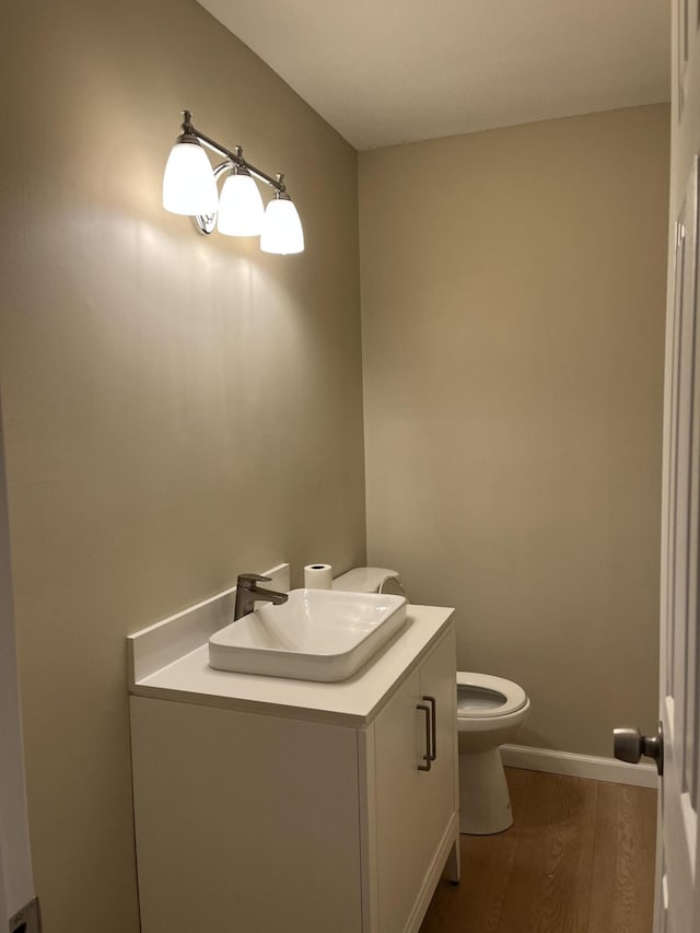 bathroom featuring vanity, hardwood / wood-style floors, and toilet