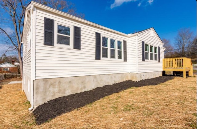 view of side of property featuring a yard and a deck