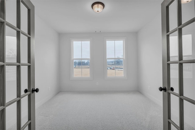 carpeted spare room with french doors