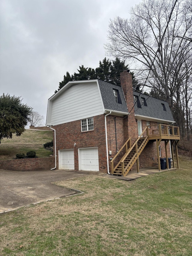 rear view of house featuring a yard, a garage, and a wooden deck