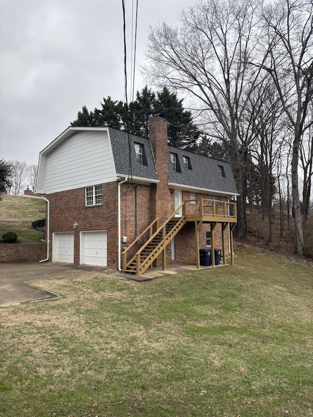 back of house with a garage, a deck, and a lawn