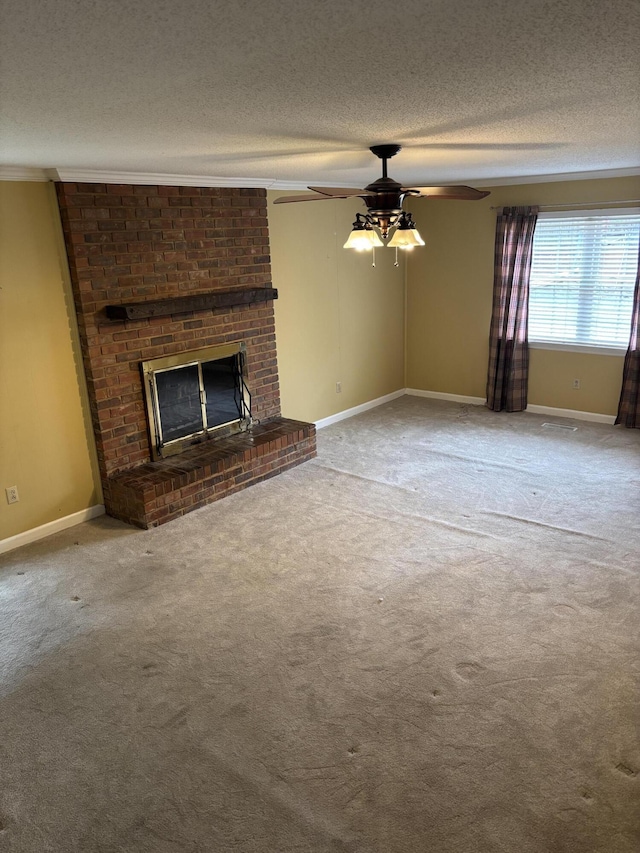 unfurnished living room featuring a fireplace, crown molding, carpet floors, and a textured ceiling