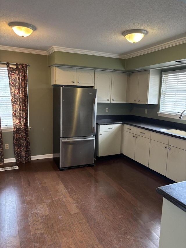 kitchen with white cabinetry, sink, stainless steel fridge, and dark hardwood / wood-style floors