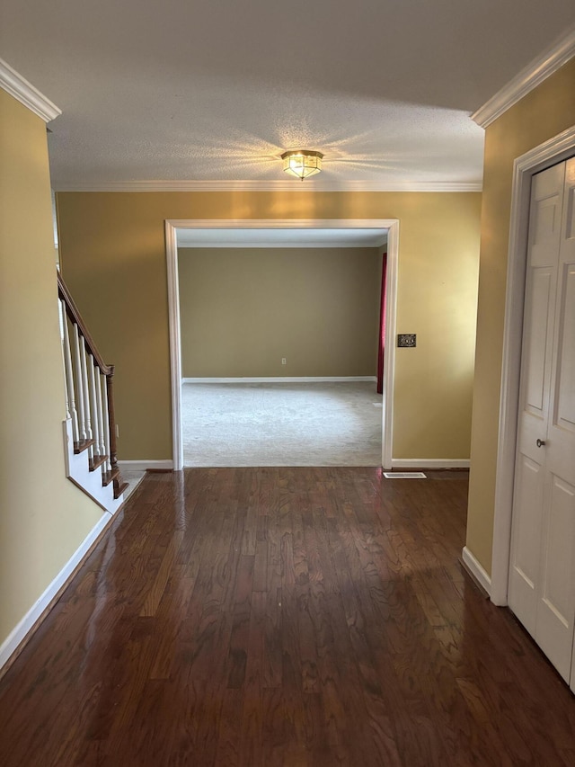 hallway featuring crown molding, dark hardwood / wood-style flooring, and a textured ceiling