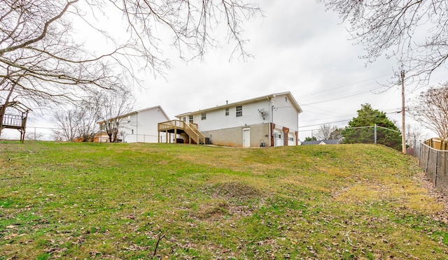 back of house with a deck and a lawn