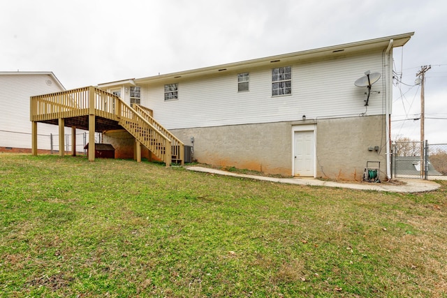 back of property featuring a wooden deck and a yard