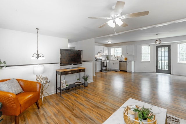 living room with ceiling fan, sink, and dark hardwood / wood-style flooring