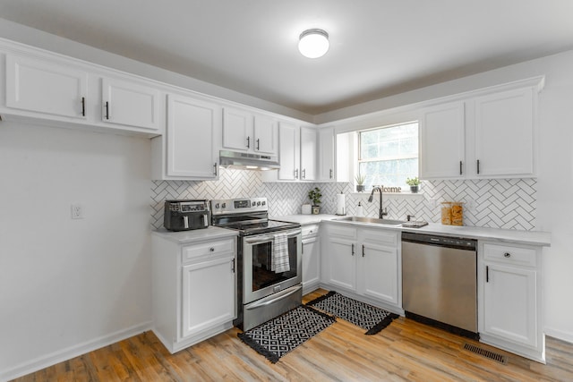 kitchen featuring sink, stainless steel appliances, white cabinets, and light wood-type flooring