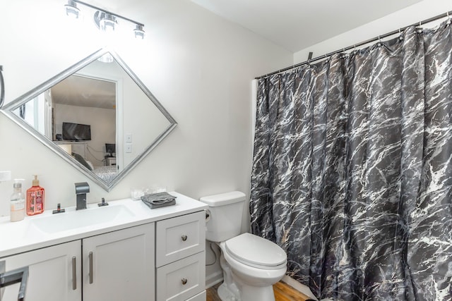 bathroom with hardwood / wood-style flooring, vanity, walk in shower, and toilet