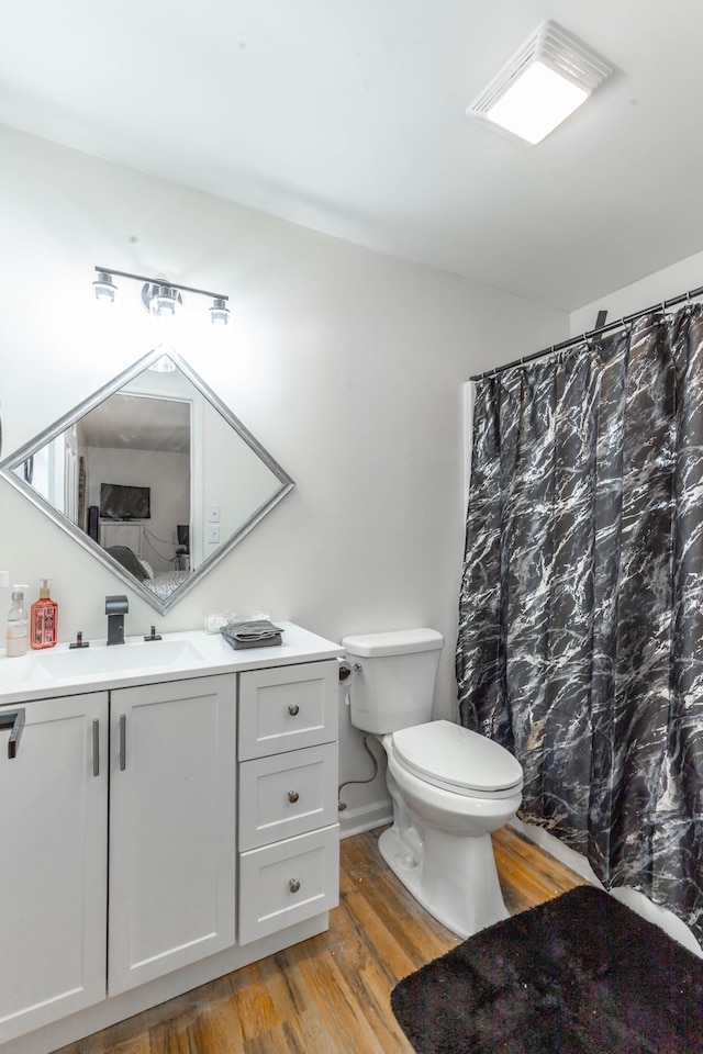 bathroom with vanity, hardwood / wood-style flooring, a shower with curtain, and toilet