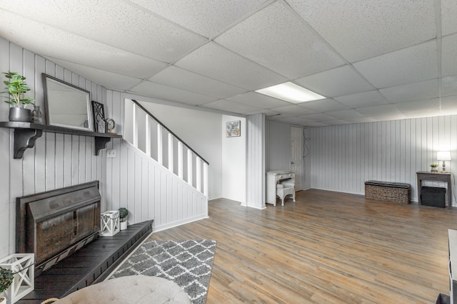 living room featuring a paneled ceiling and wood-type flooring