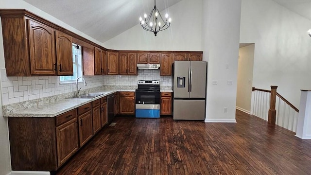 kitchen featuring dark wood-type flooring, stainless steel appliances, decorative light fixtures, and sink