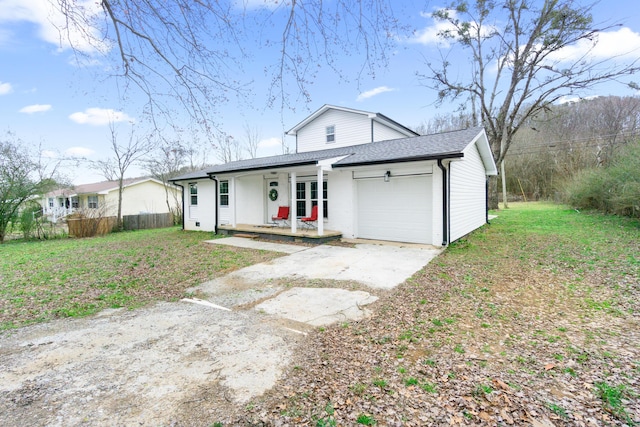 view of front of home featuring a garage, a front lawn, and covered porch