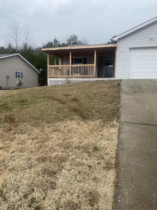 view of front facade with a garage, a front lawn, and a porch