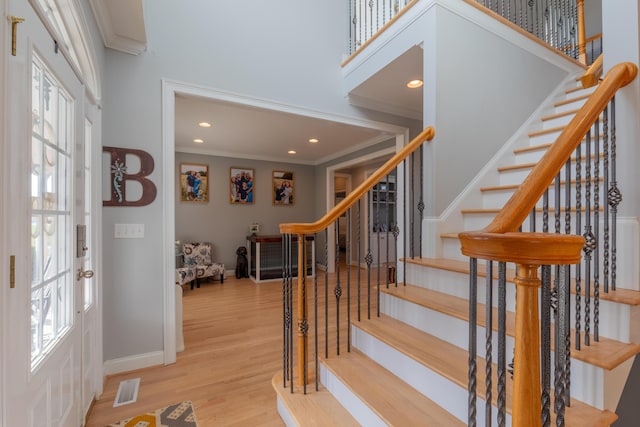 foyer with light hardwood / wood-style flooring and ornamental molding